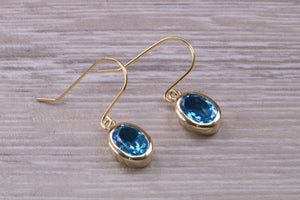 Oval cut Blue Topaz set Yellow Gold Dropper Earrings