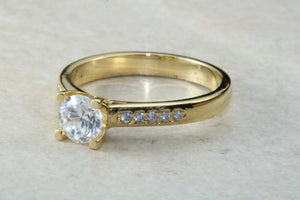 One carat Forever One grade Charled and Colvard Moissanite complemented with natural diamond on the sides of this beautiful 18ct gold ring