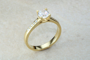 One carat Forever One grade Charled and Colvard Moissanite complemented with natural diamond on the sides of this beautiful 18ct gold ring